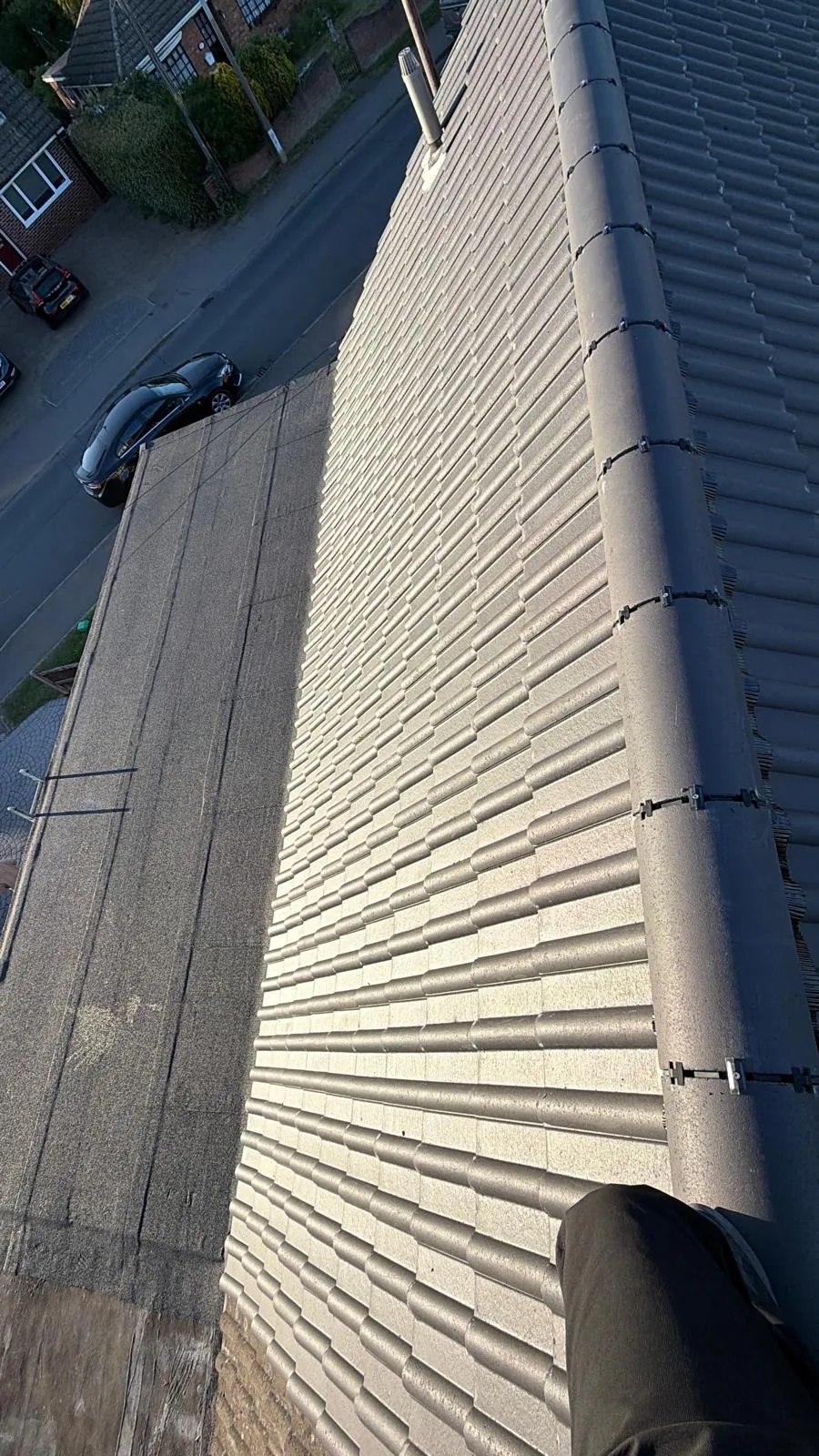 Dry ridge fixings above rows of grey concrete tiles