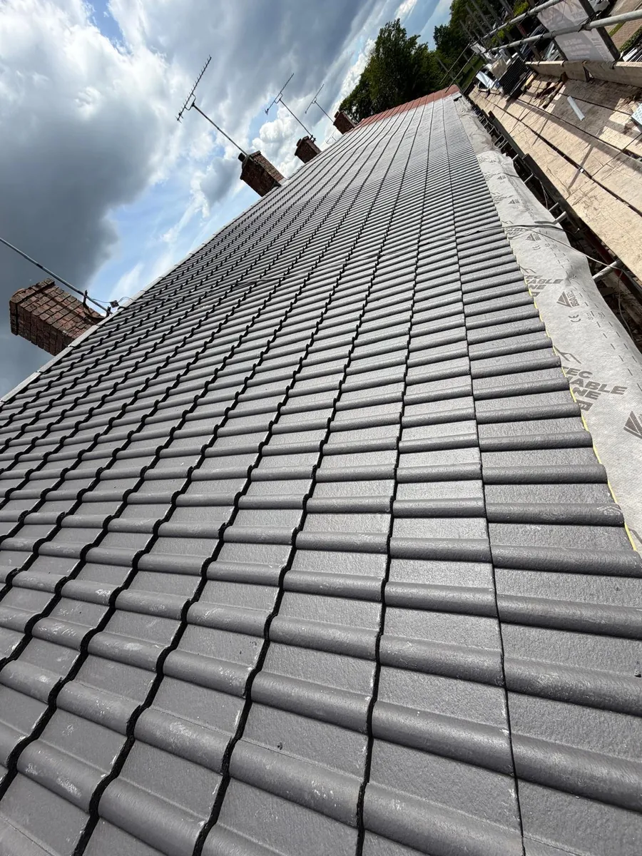 Finished grey interlocking tiled slope alongside scaffolding