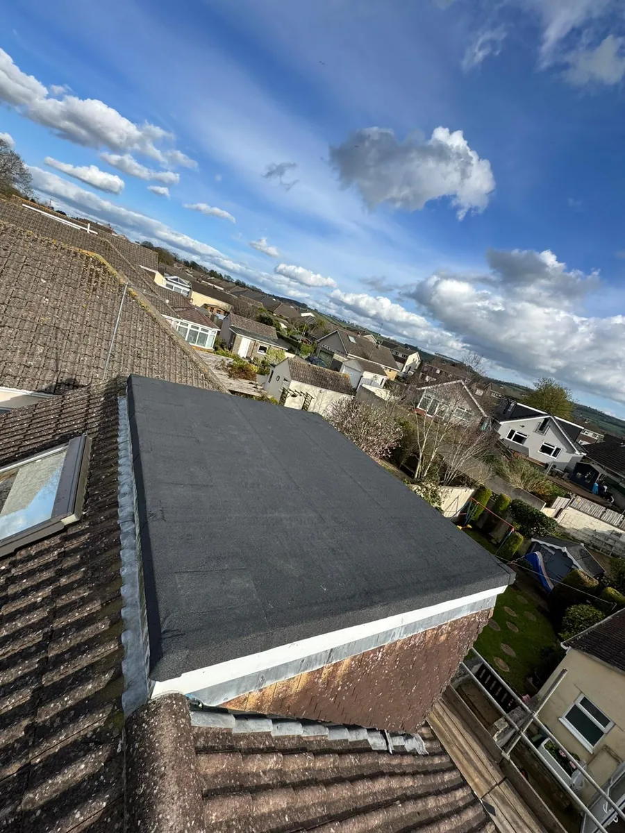 Dark flat dormer roof seen from an adjoining tiled slope