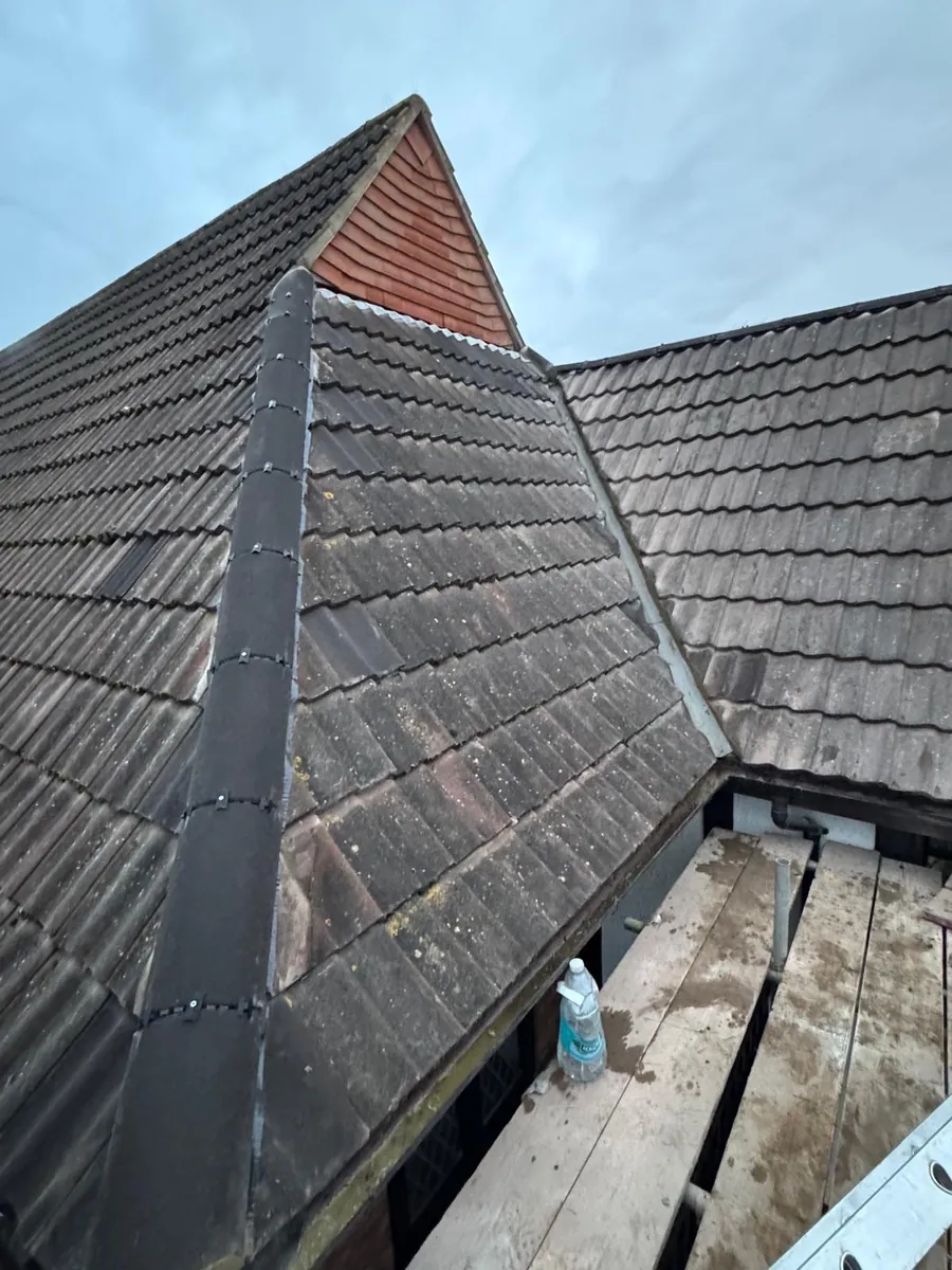 Lead covering along a hip beside a red tile-hung gable