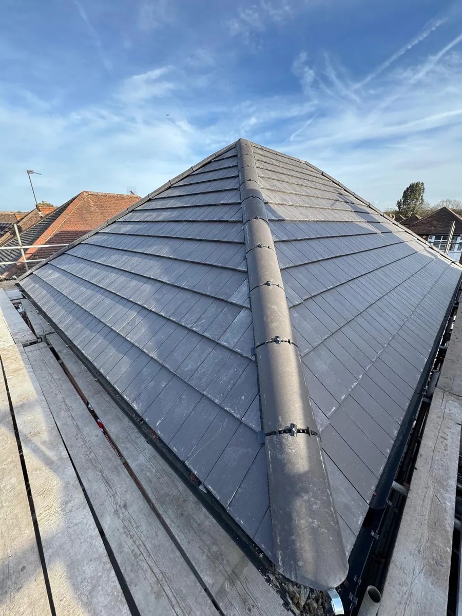 Hip and ridge tiles above fresh grey tile courses
