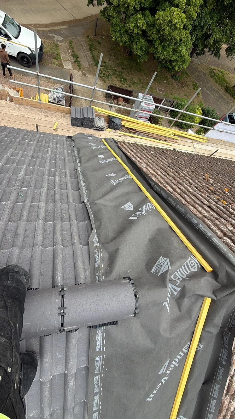 Partly tiled roof with membrane and yellow timber battens exposed