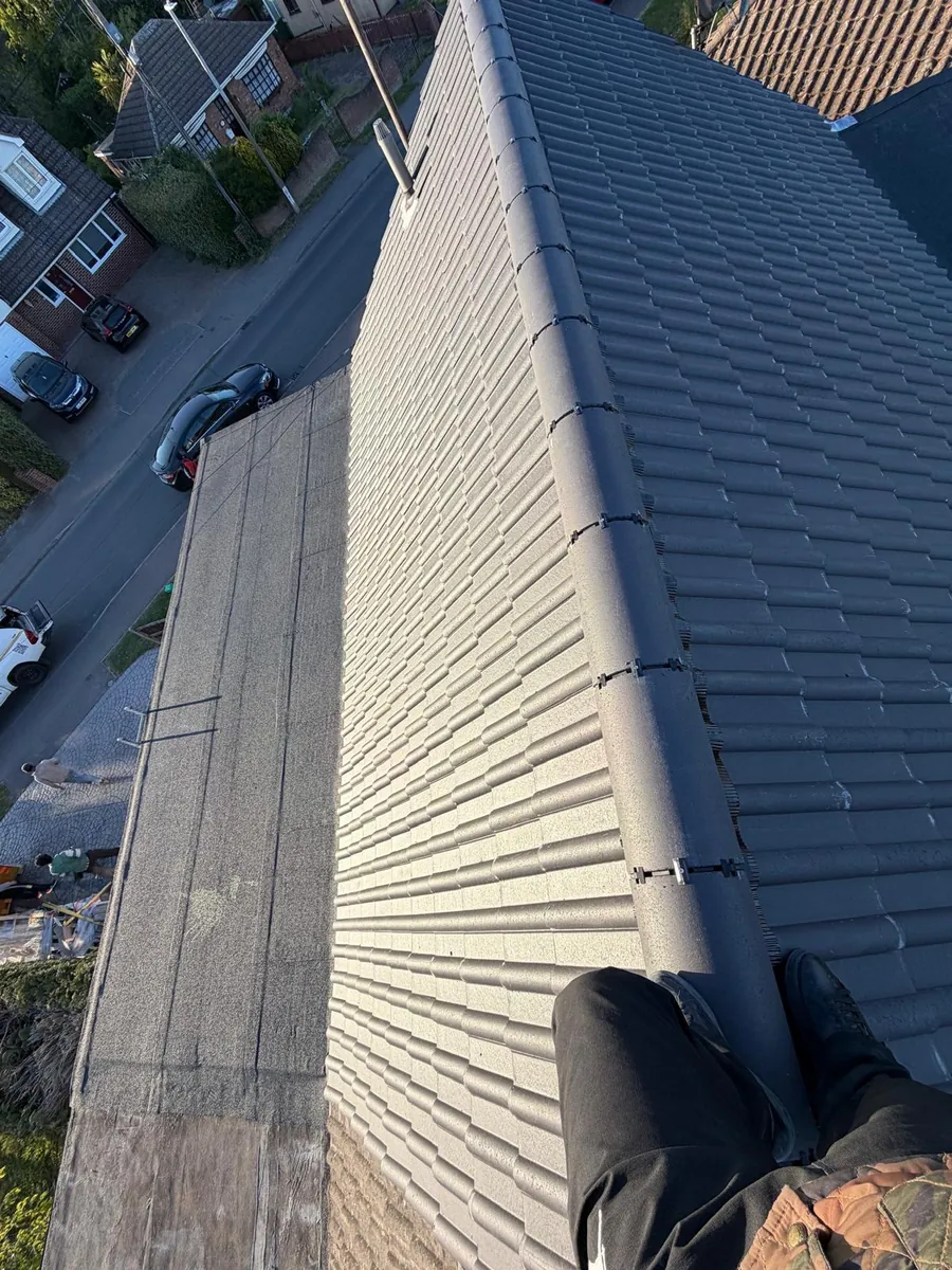 Grey concrete tile courses on both sides of a capped ridge