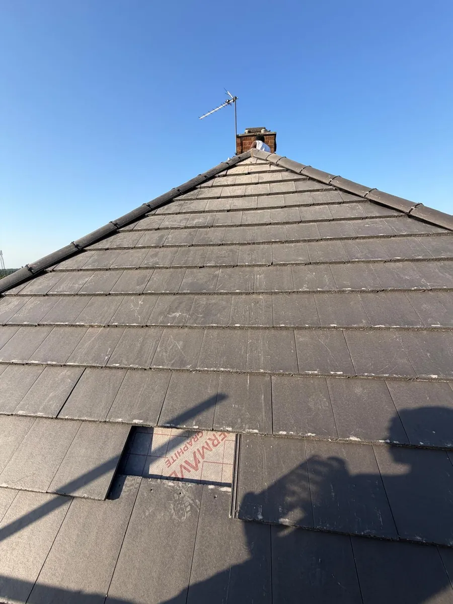 Slate-effect tiled slope leading up to a brick chimney