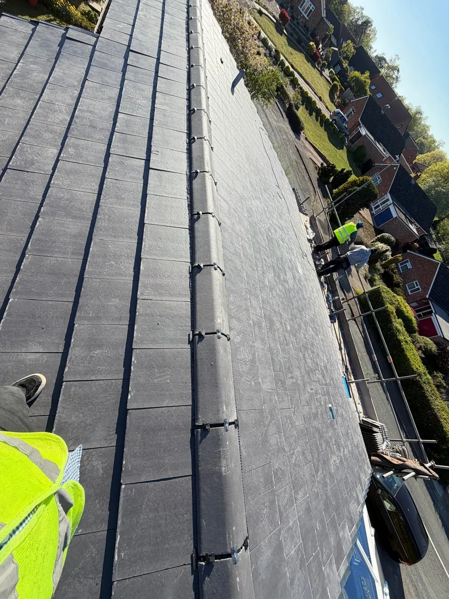 Tile courses at the eaves with roofers on the scaffold