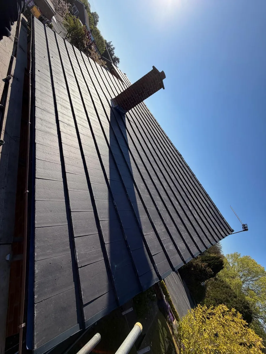 New slate-effect tiled slope beside a brick chimney stack